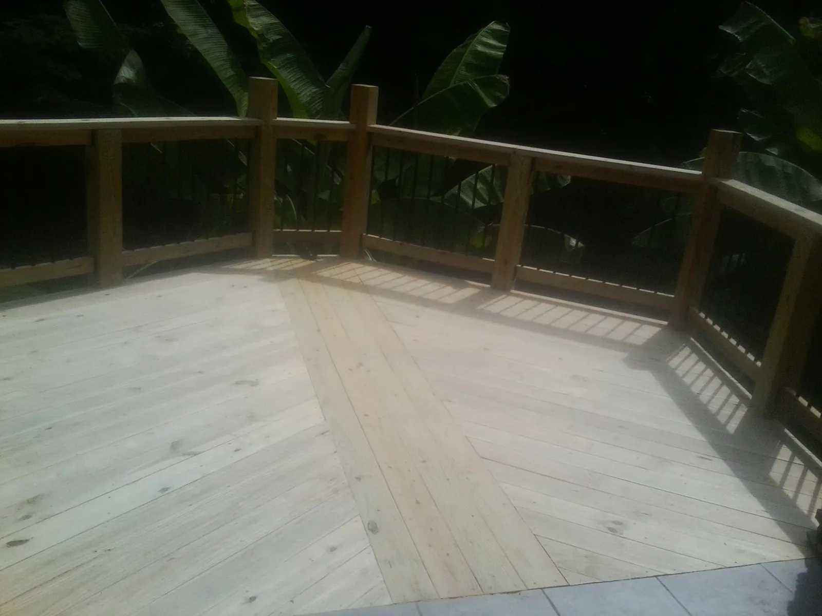 New wood deck and railing built off the back of a home in Van Meter