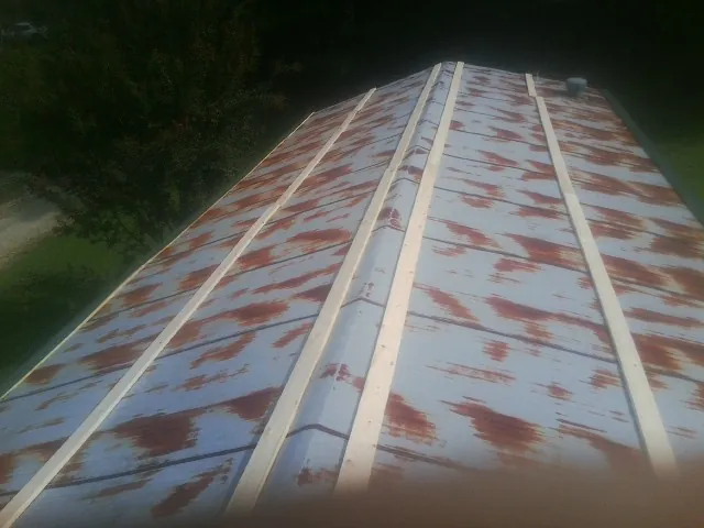 Rusted metal roof panels with new wood purlins before replacement — Storm Damage Roof Repair in Van Meter by Roofing Brothers