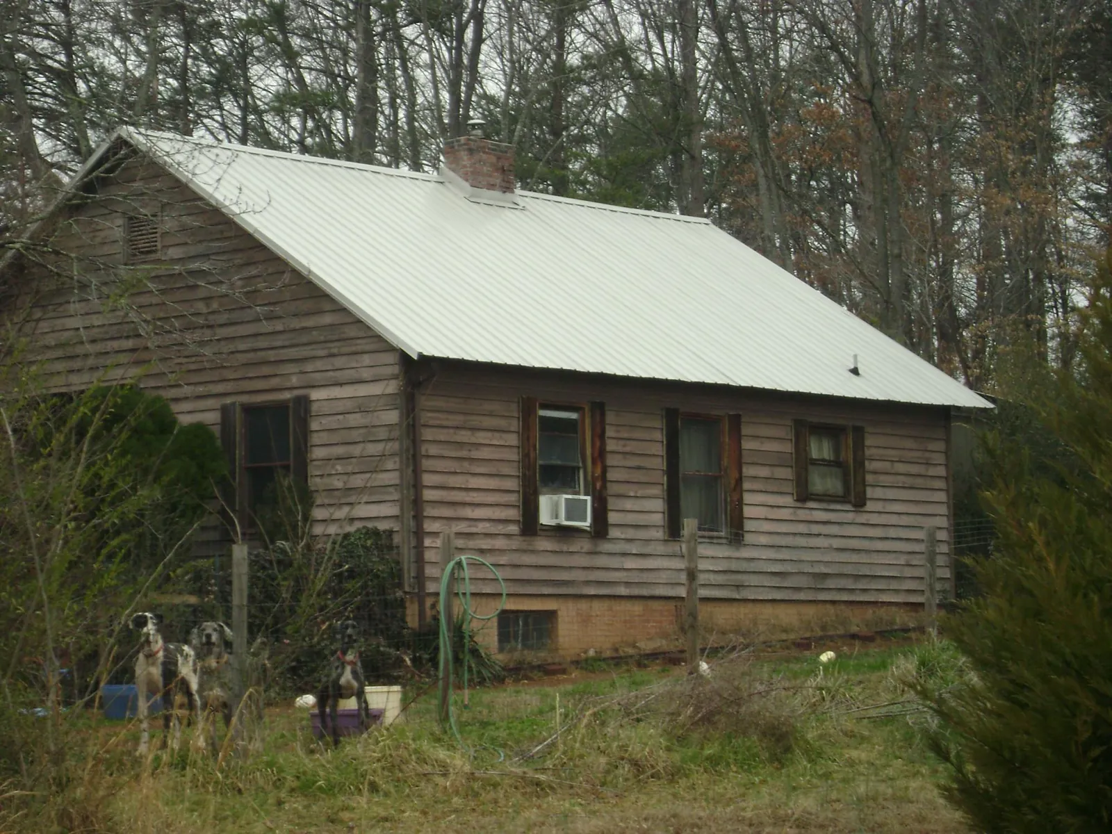 White metal roof on an old wood sided farmhouse, from a Metal Roof Installation job in Van Meter